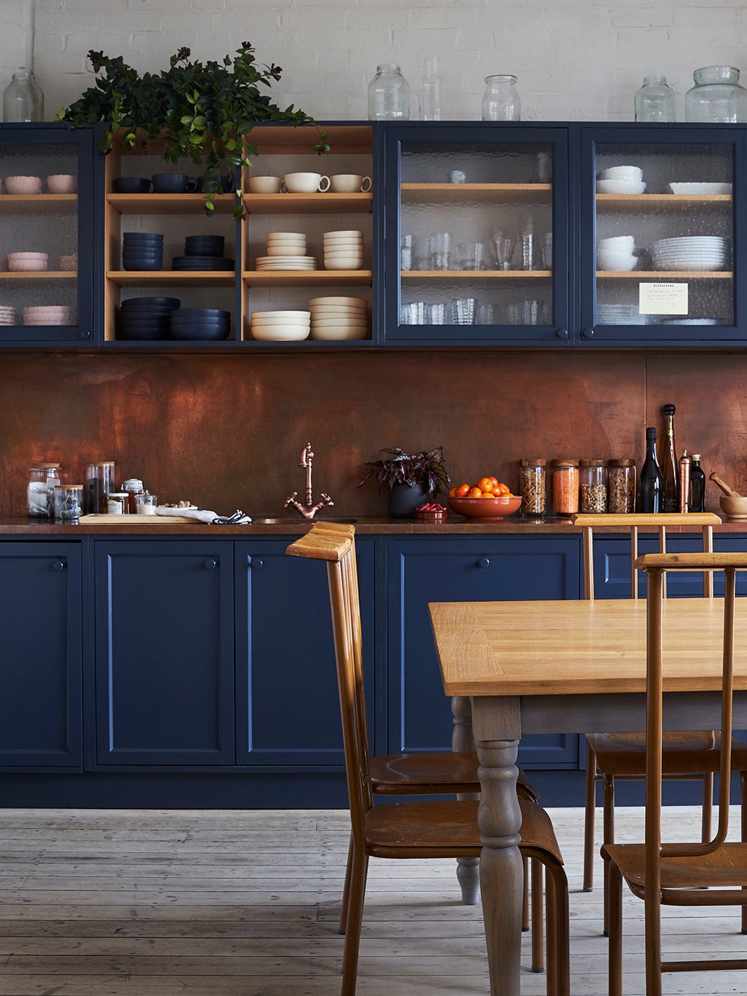 navy kitchen cabinets with copper backsplash