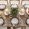 outdoor dining table with brown linens and white plates