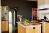 Kitchen with black cabinets and pink and green alcoves