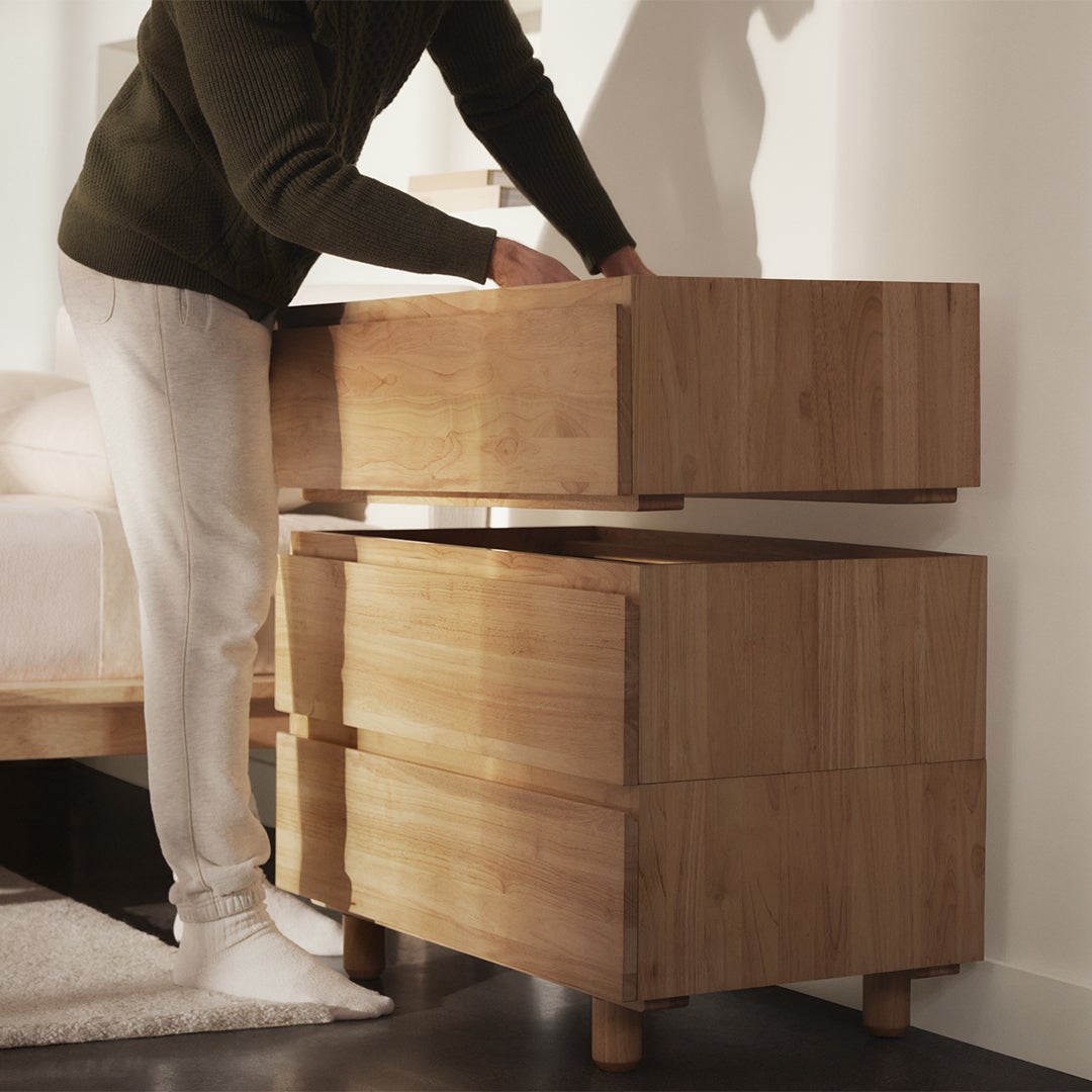 Man stacking drawers of dresser