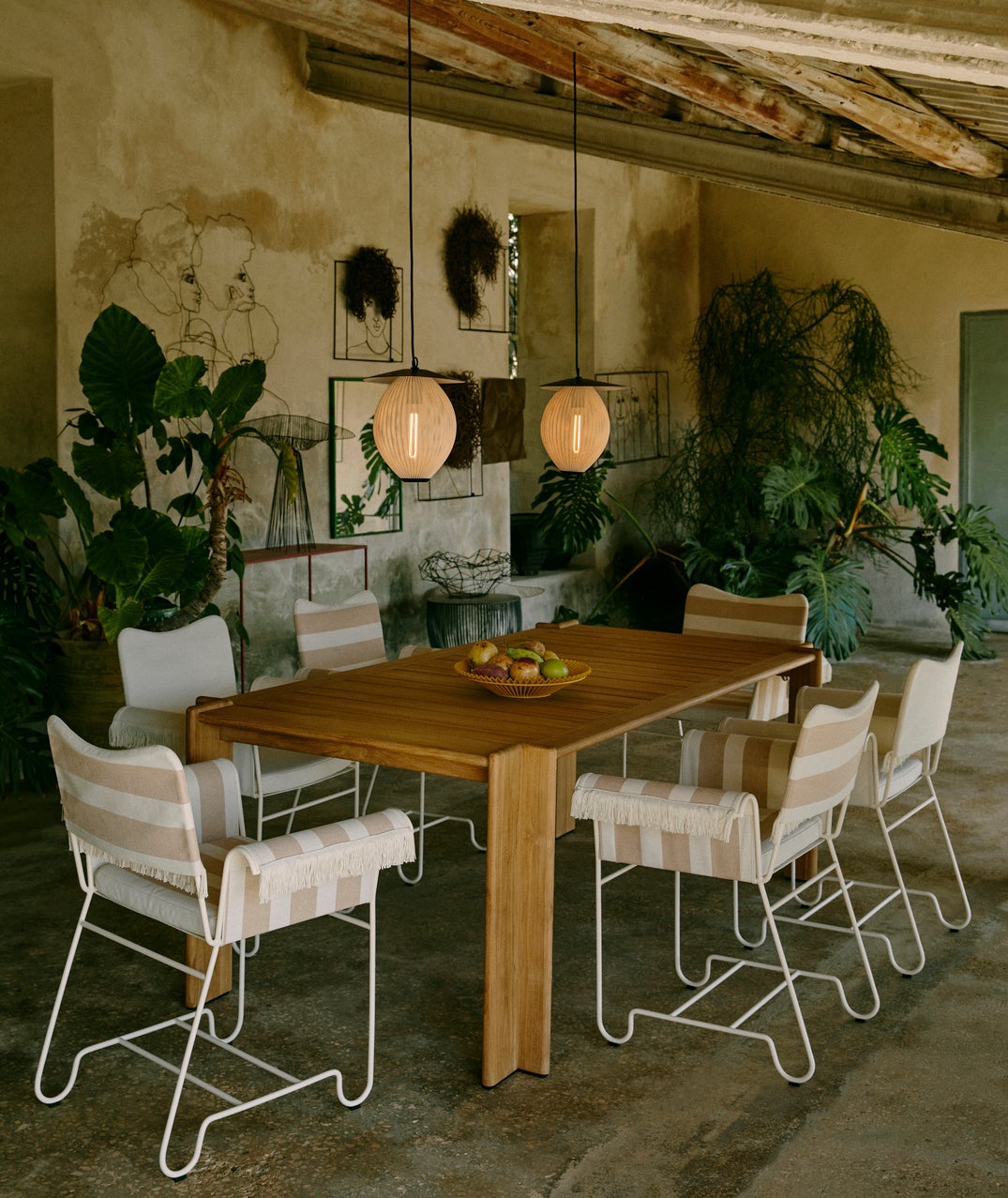 plant-filled dining room with 2 pendant lights