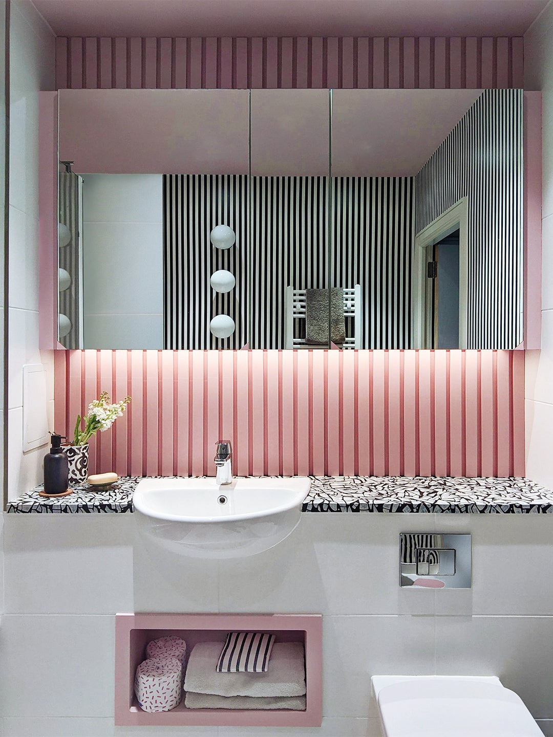 pink wood paneling behind mirror