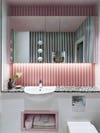 pink wood paneling behind mirror