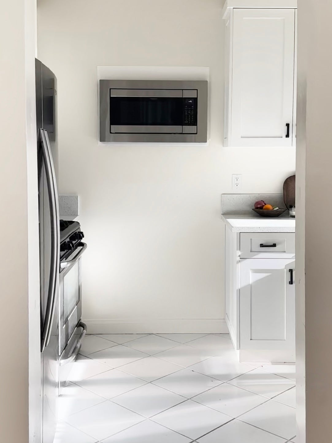 white kitchen with microwave in wall
