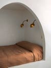 Bed nook with rust-colored bedding