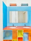 Bathroom with blue, yellow, and orange acrylic cabinets