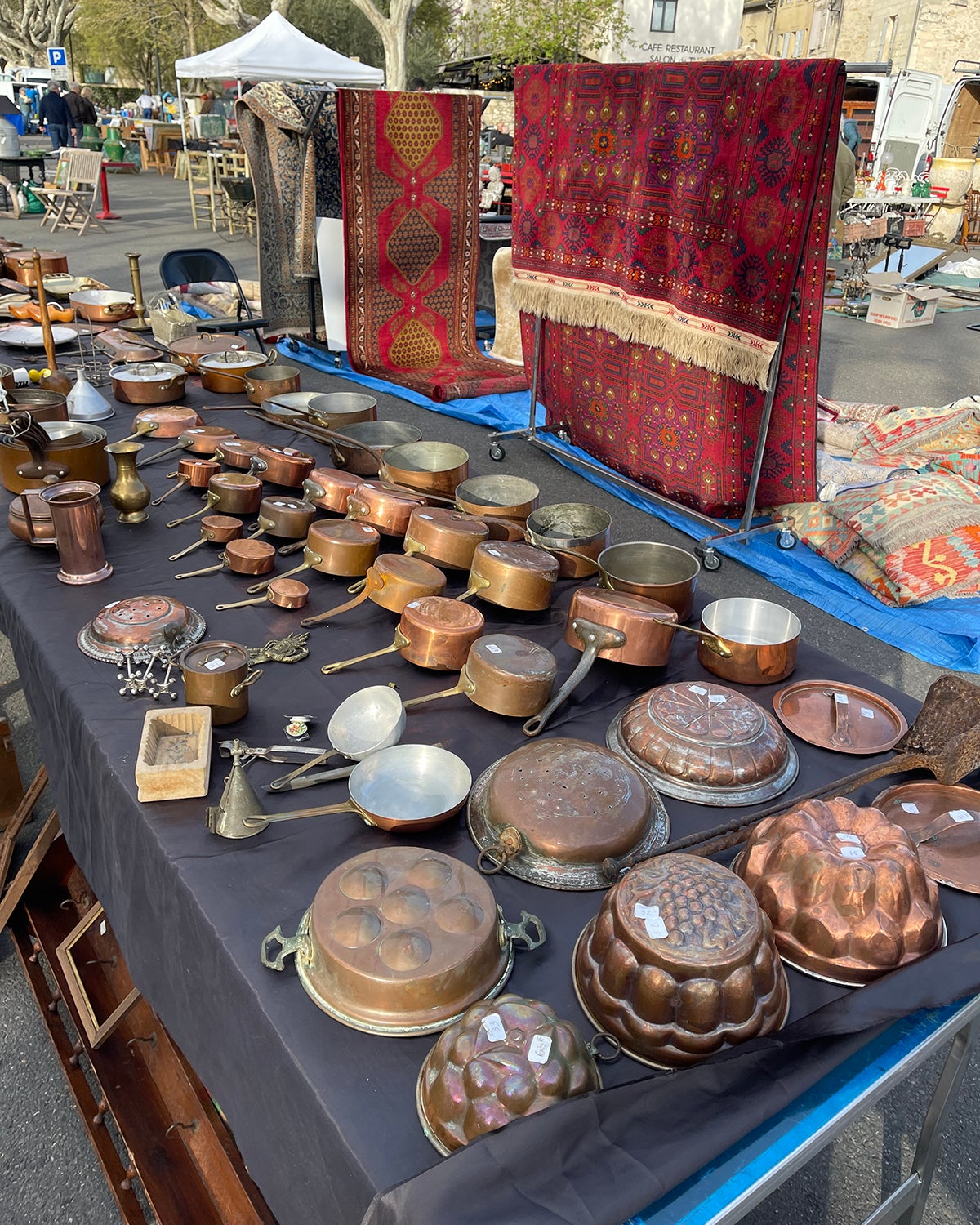 Table full of copper pots at a flea market