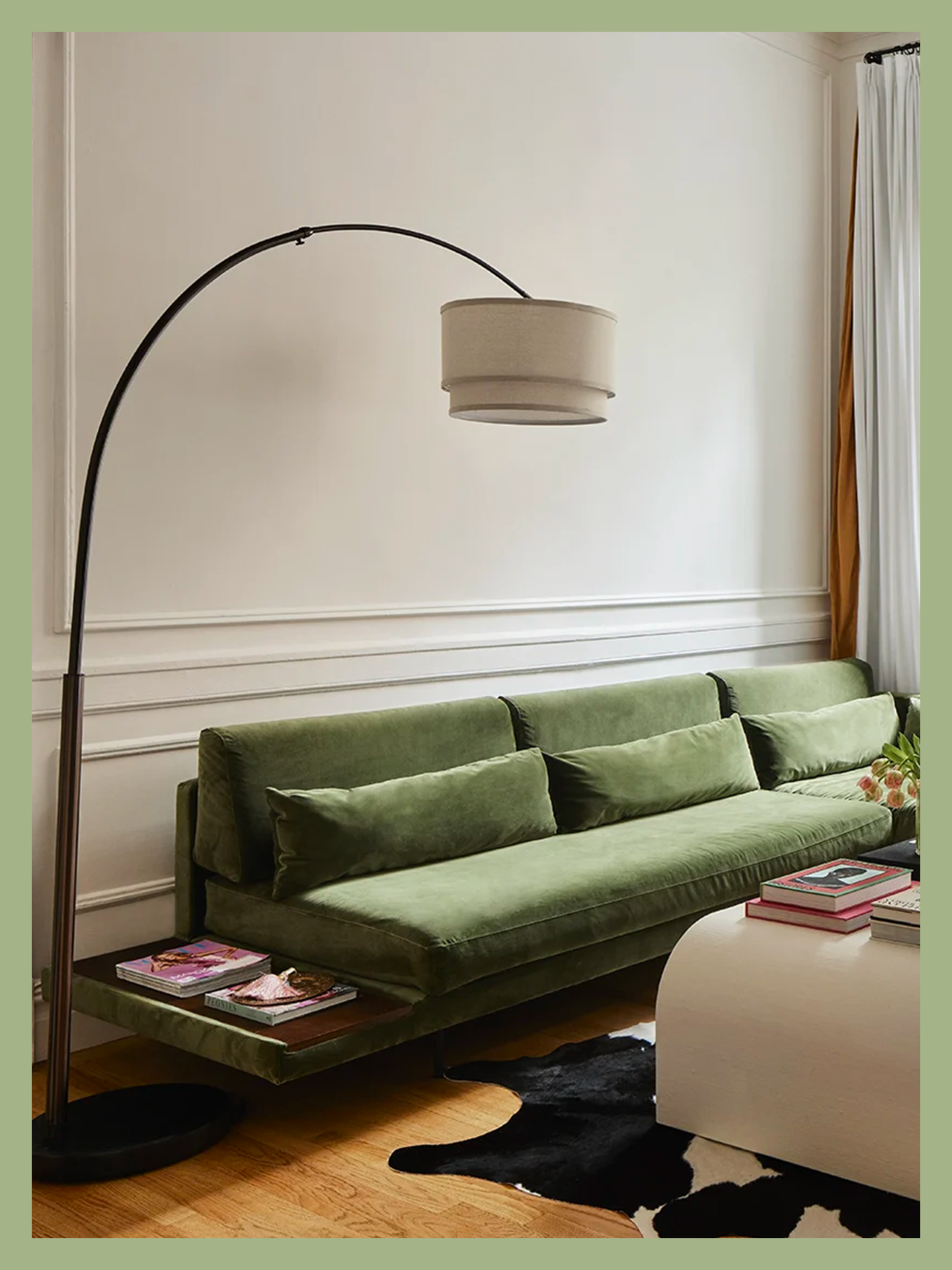 green velvet couch in living room with arched bronze lamp curved overhead in Brynn Whitfield's living room