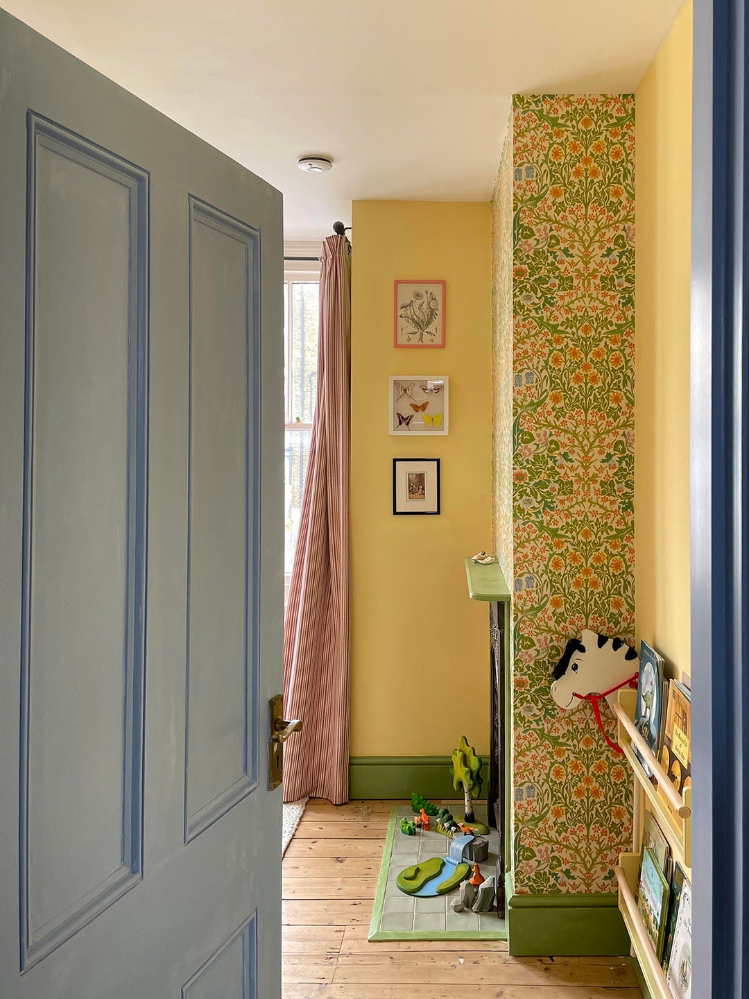 yellow kid's room with floral wallpapered fireplace