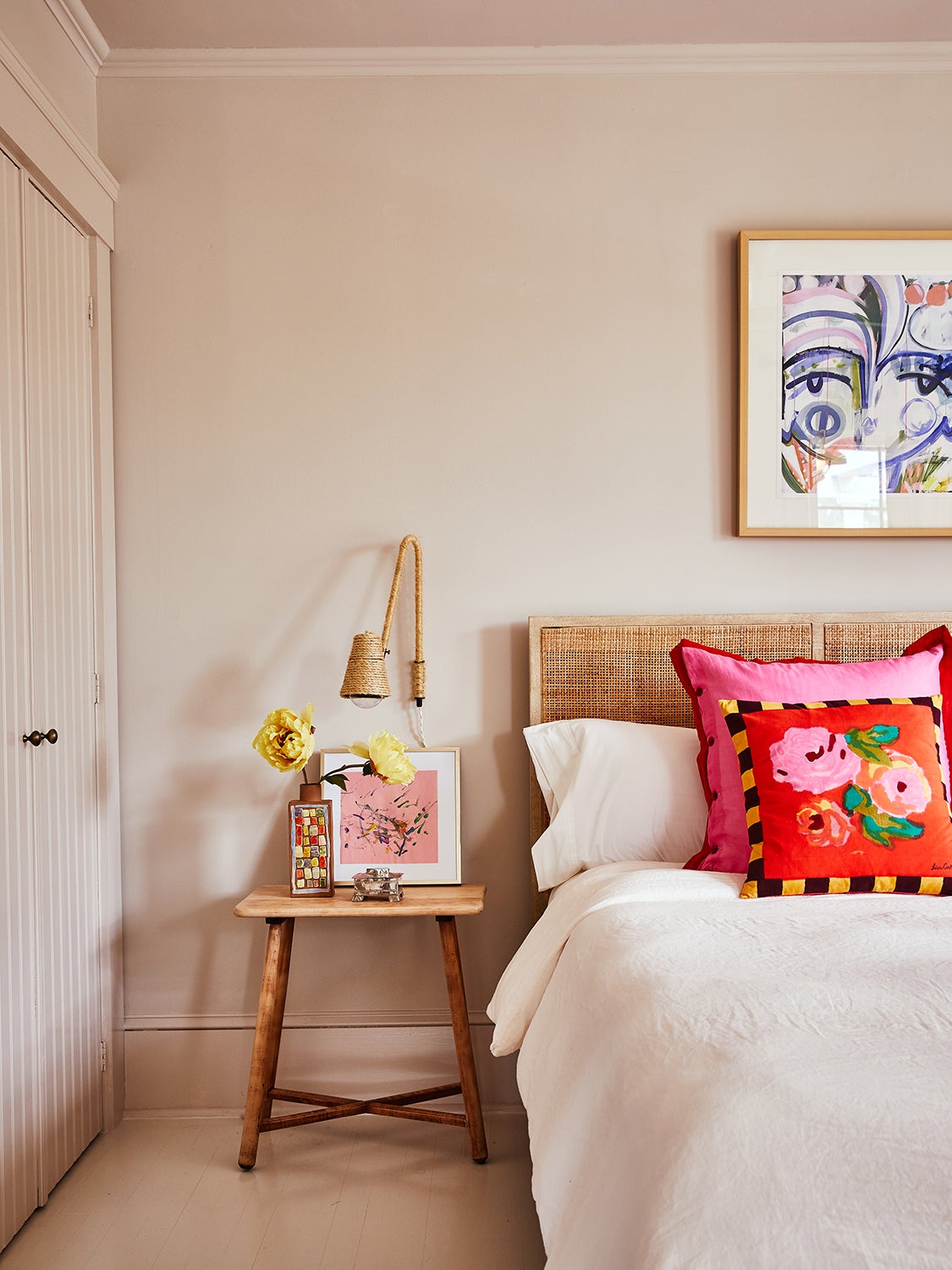 Bedroom with soft pink walls and bright pink pillows