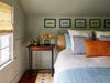 Upstairs bedroom with fish prints above the bed