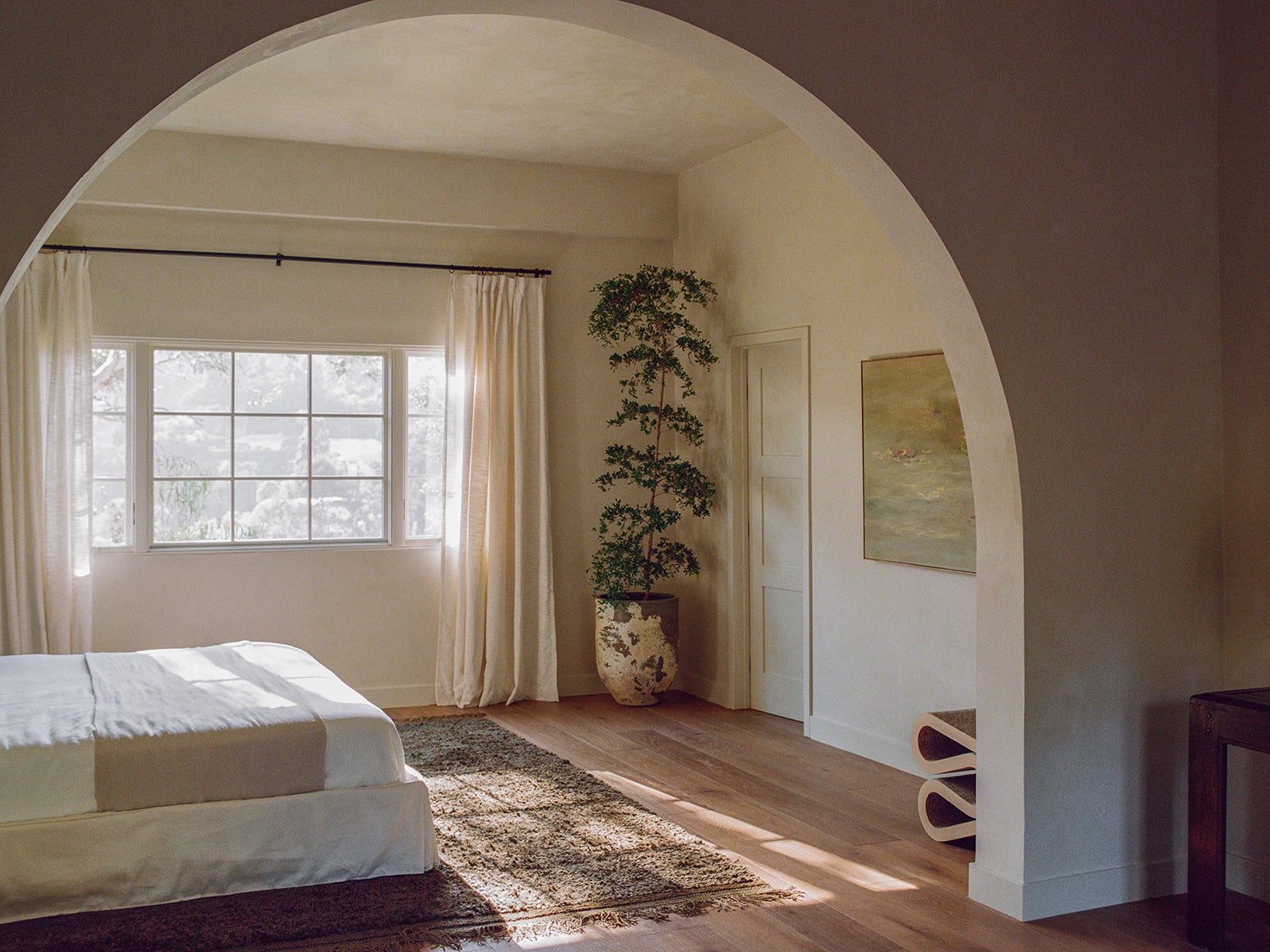 archway separating bedroom and den