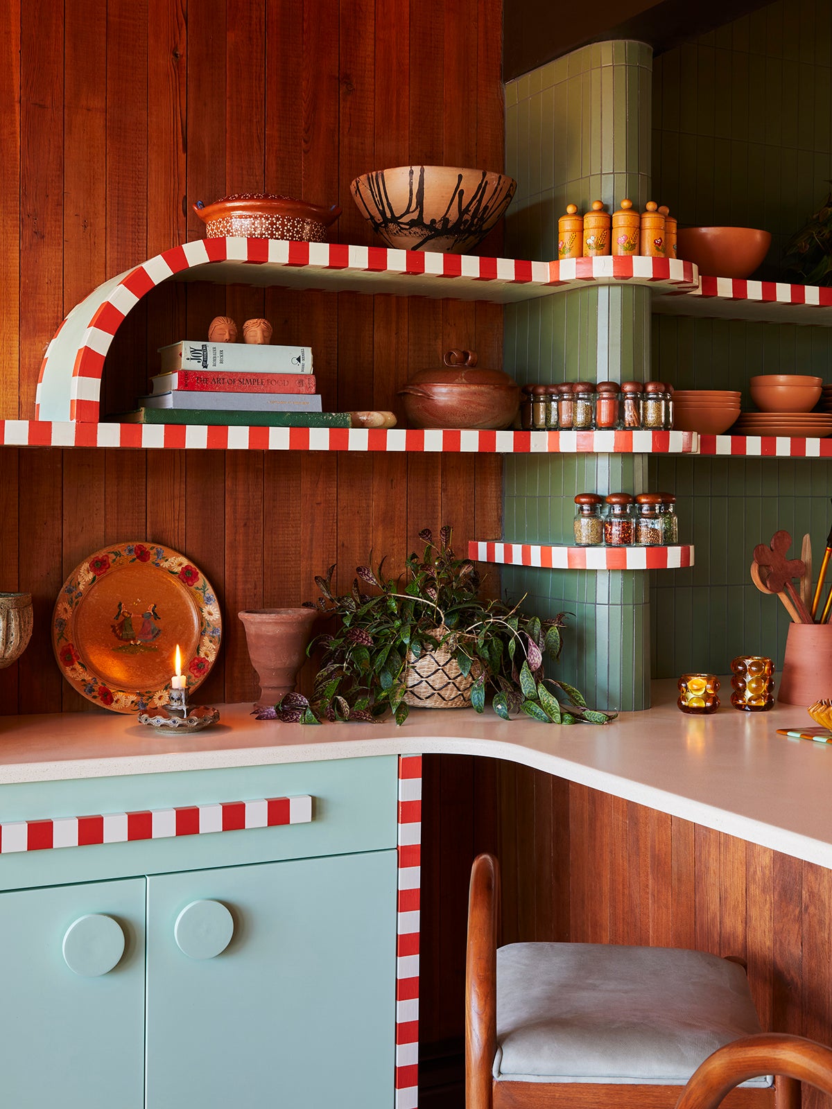 Kitchen shelving with wood-paneled walls and candy striped open shelving