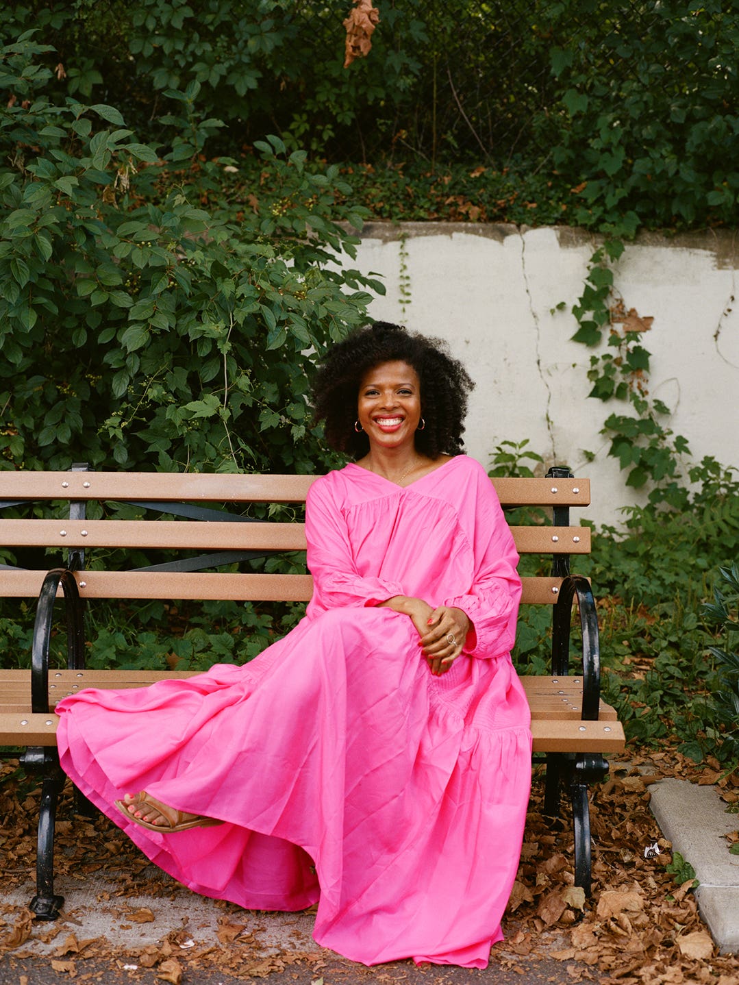 Woman on bench in a Barbie pink dress