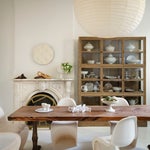 White dining room with wooden table and fireplace