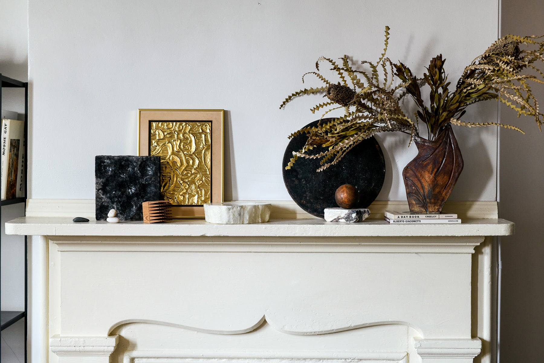 Mantel with art and a vase