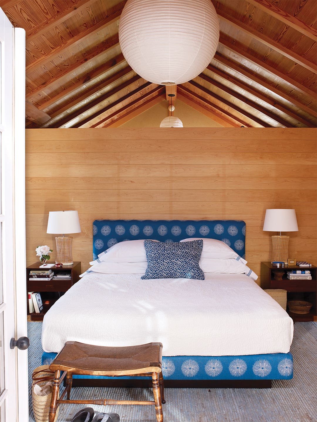 Woodpaneled room with blue bed