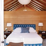 Woodpaneled room with blue bed