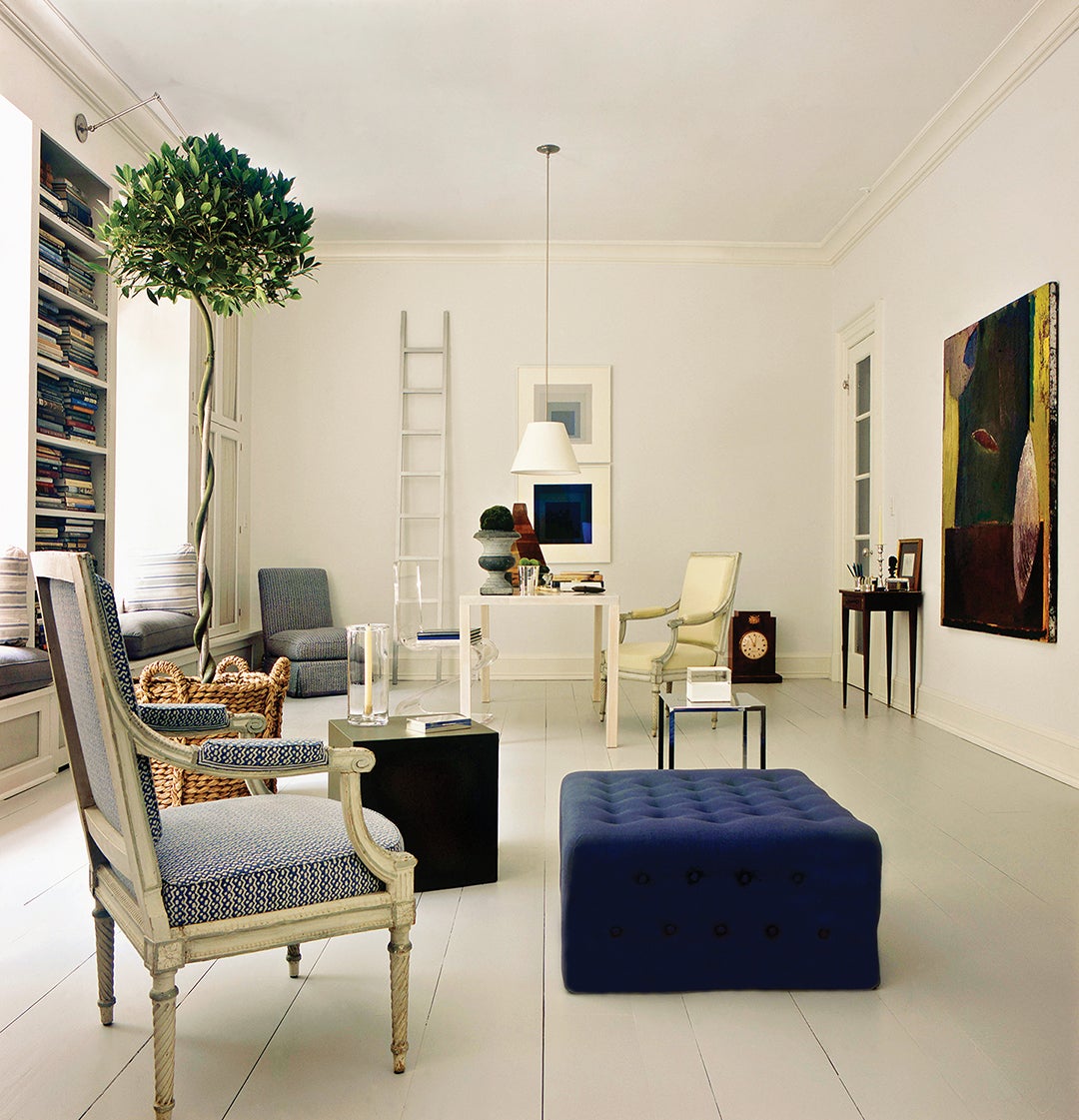 Sparse room with blue ottoman and white walls