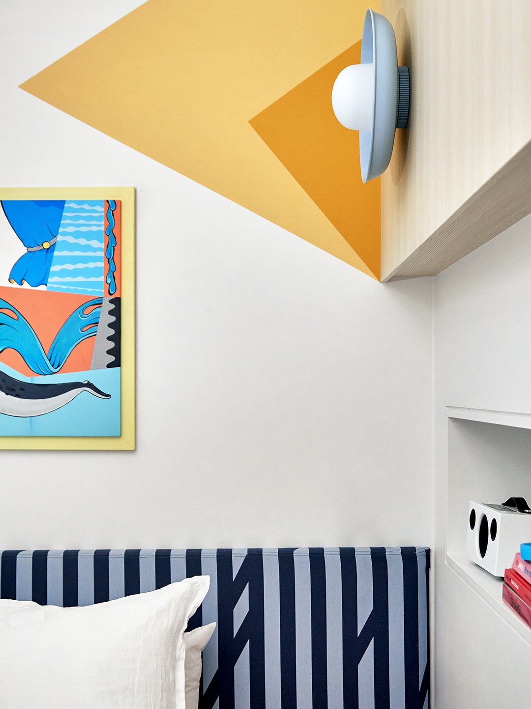 Kid's bedroom with striped headboard and yellow painted wall.
