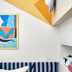 Kid's bedroom with striped headboard and yellow painted wall.