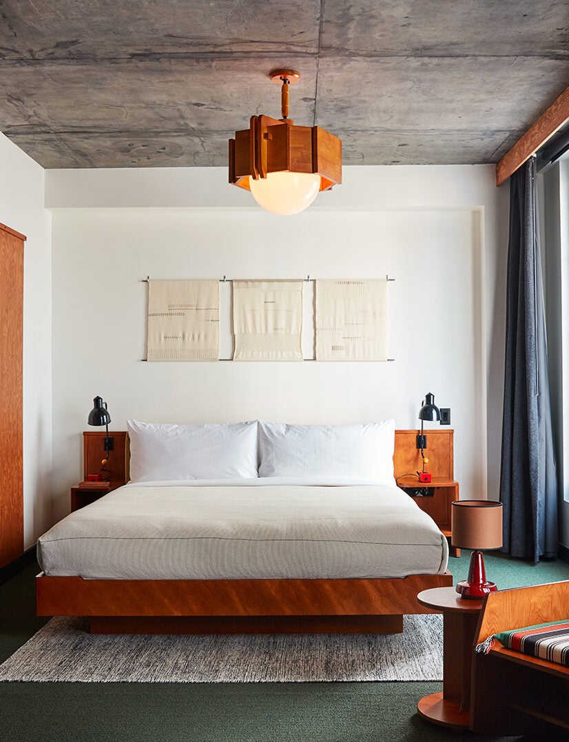 Hotel room with bed and wood lamp.