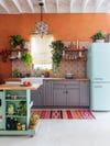kitchen with orange walls and sky blue fridge