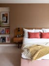 Bed with grasscloth wallpaper and bedside table bookshelves.