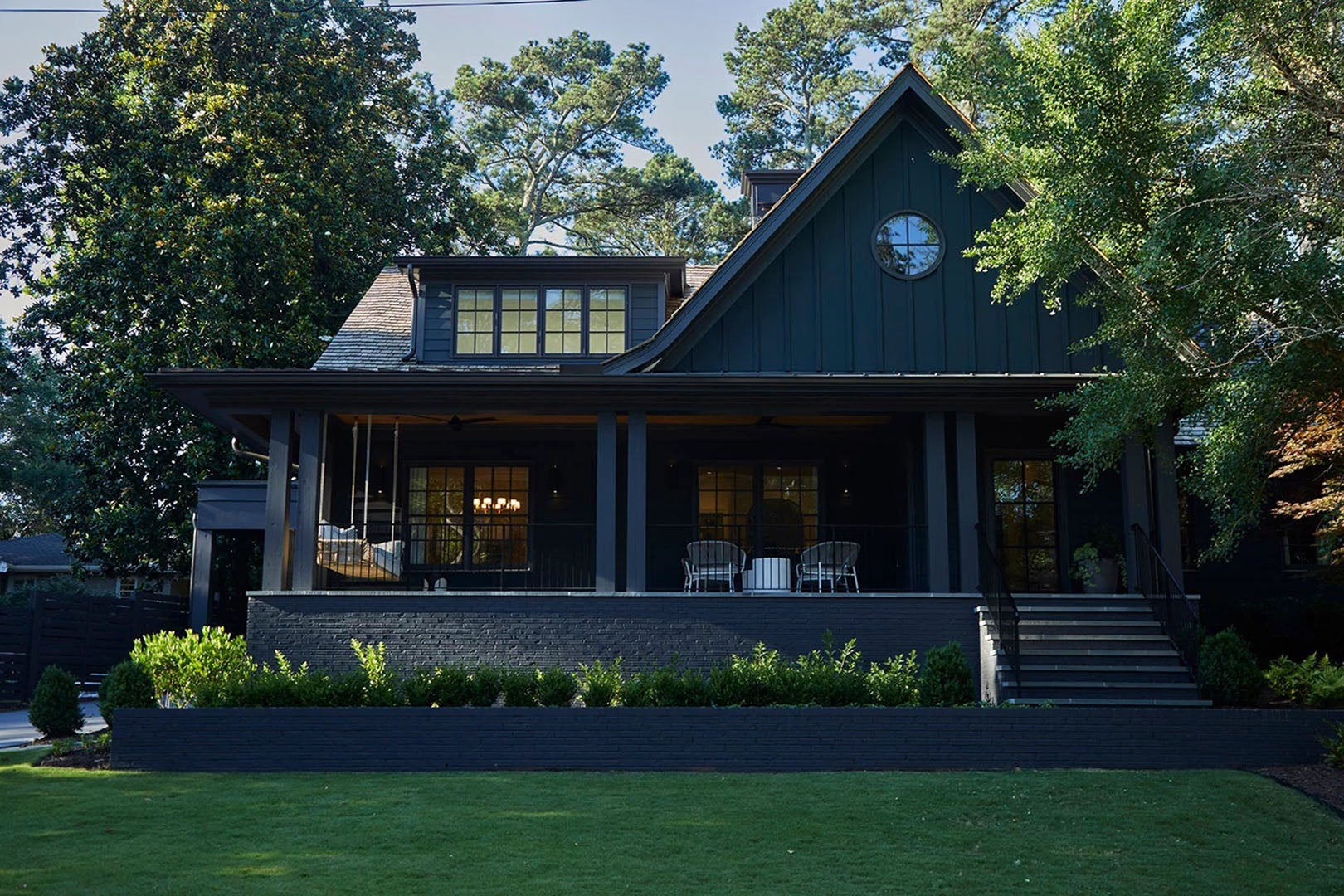 Black exterior house with green lawn.