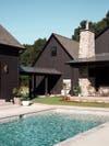 Black exterior house with pool.
