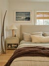Bedroom with an upholstered headboard and linen sheets