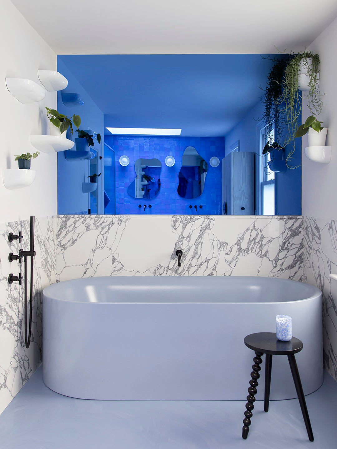 Blue tiled bathroom with blue freestanding tub.