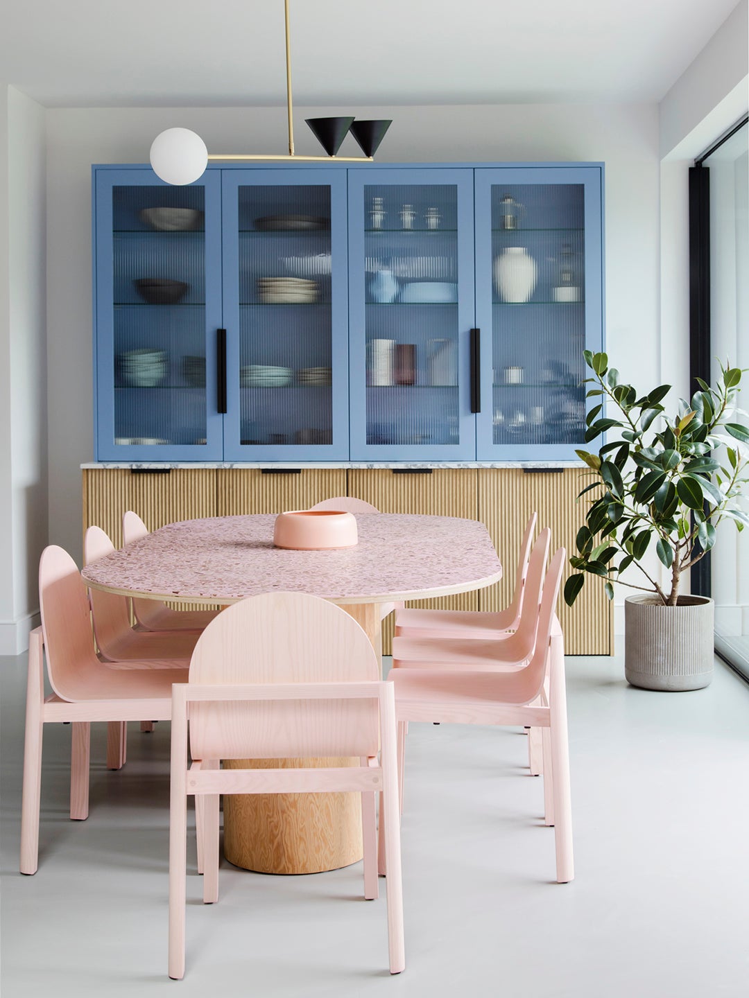 Dining room with pink dining set and blue cabinets.