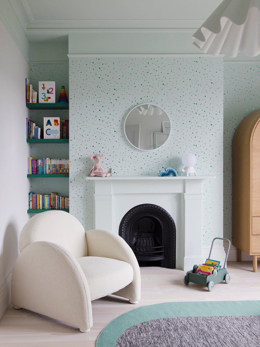 Kid's room with cream chair and bookshelf.