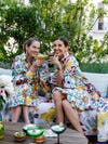 Two women in matching dresses with drinks