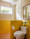 Sunny bathroom with two shades of yellow tiles. 