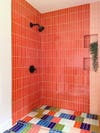 Bathroom with coral, green, blue, and white tiles.