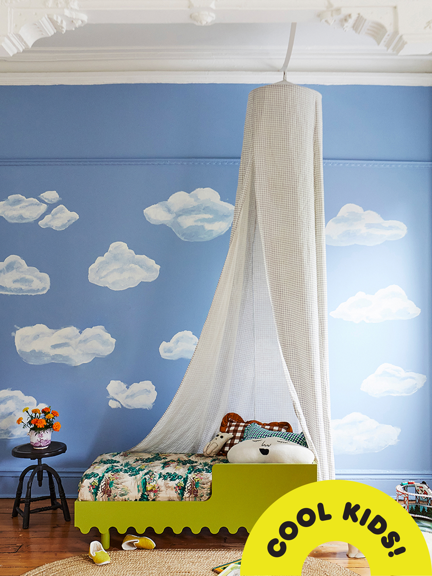 Oeuf's Moss Toddler bed in peapod green in bedroom with a canopy and walls painted with clouds