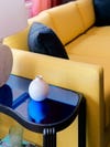 shiny blue table next to yellow sofa