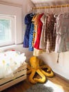 Kid's closet with clothing hanging and yellow octopus toy on floor.