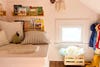 Kid's closet with pillows on a bench and bookshelves creating a reading nook.