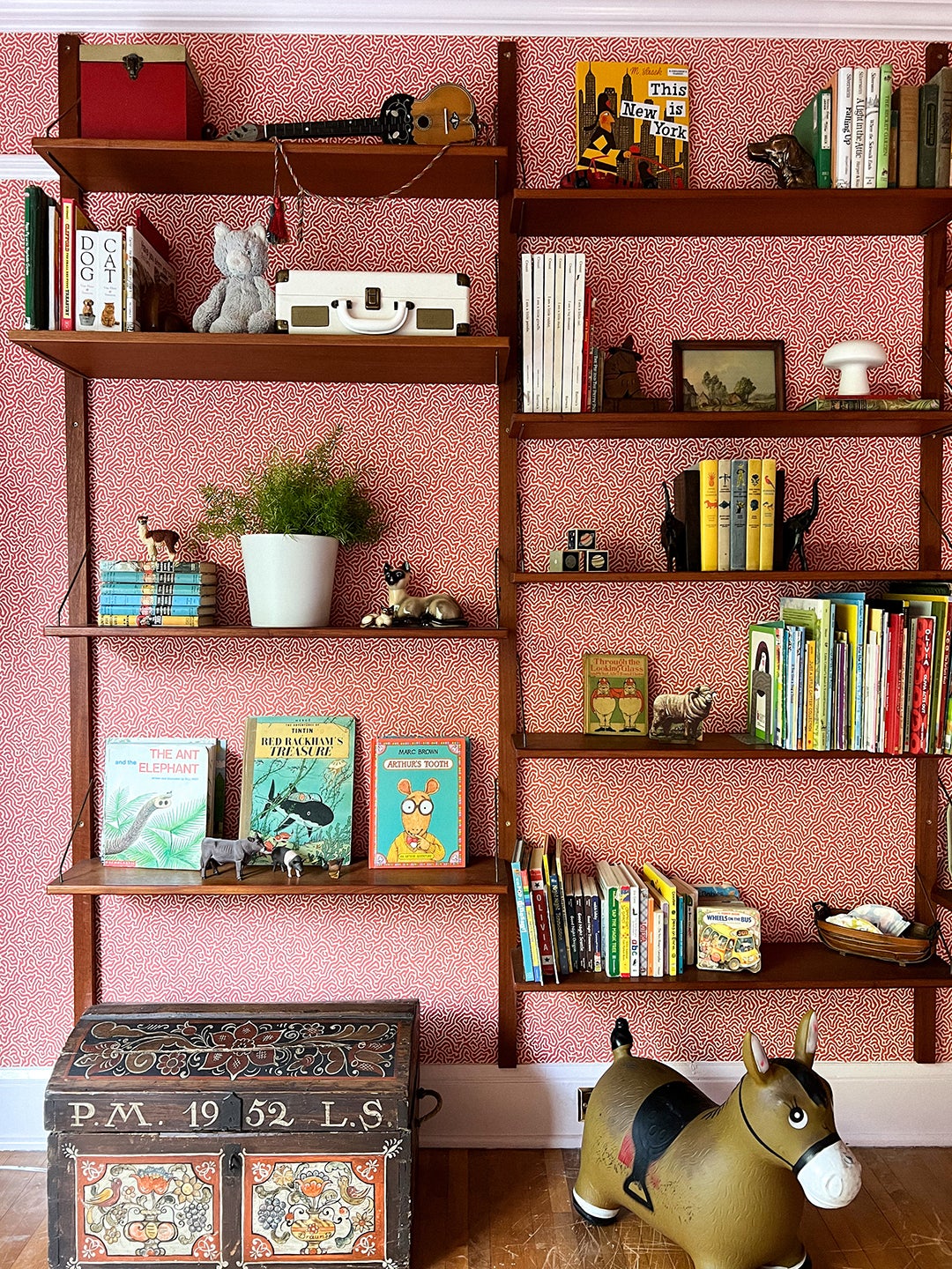 Kid's room detail of vintage teak wall-mounted bookshelves.