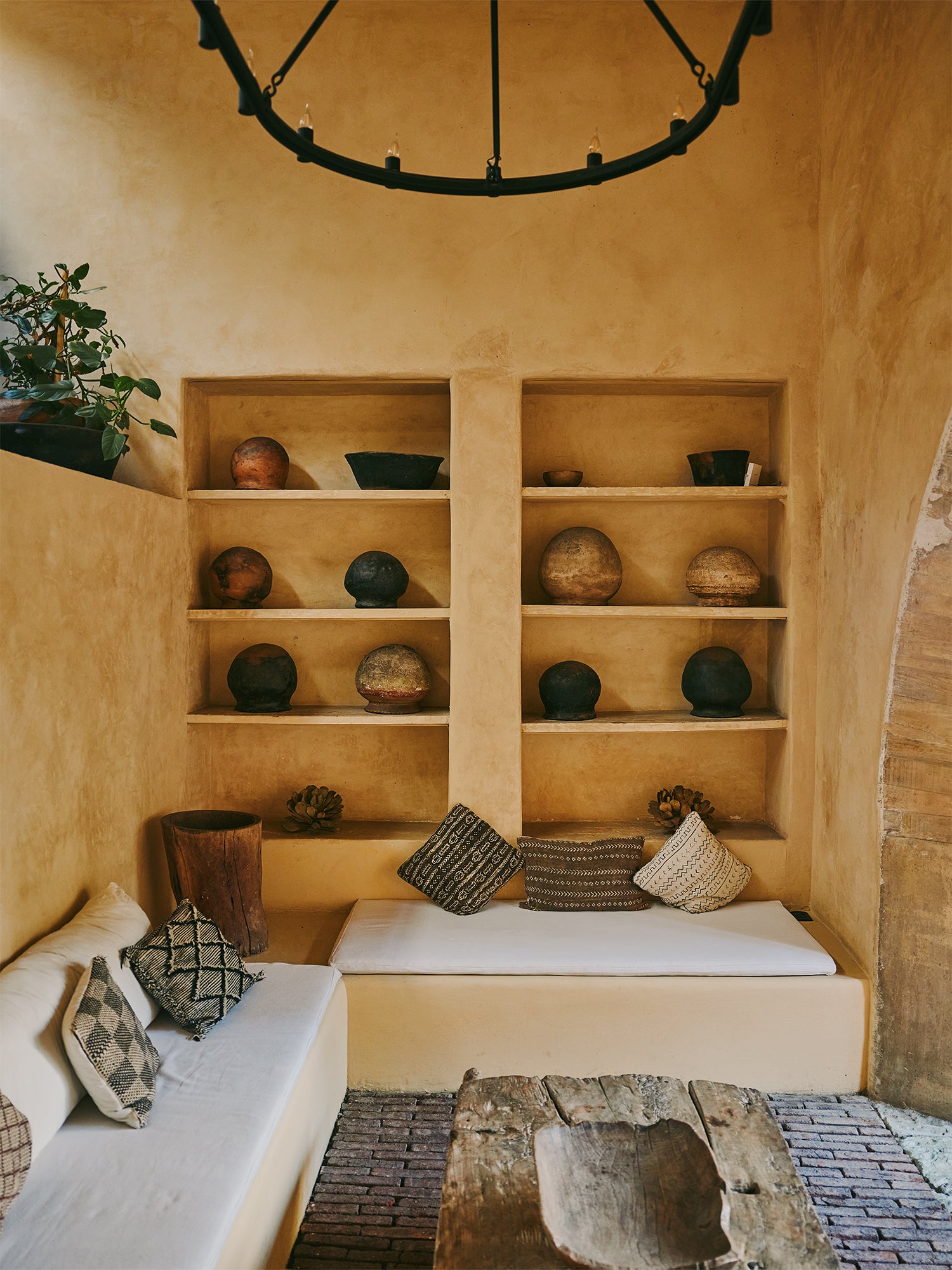 Corner sofas with recessed bookshelves and plaster walls behind in Hotel Escondido, Oaxaca.