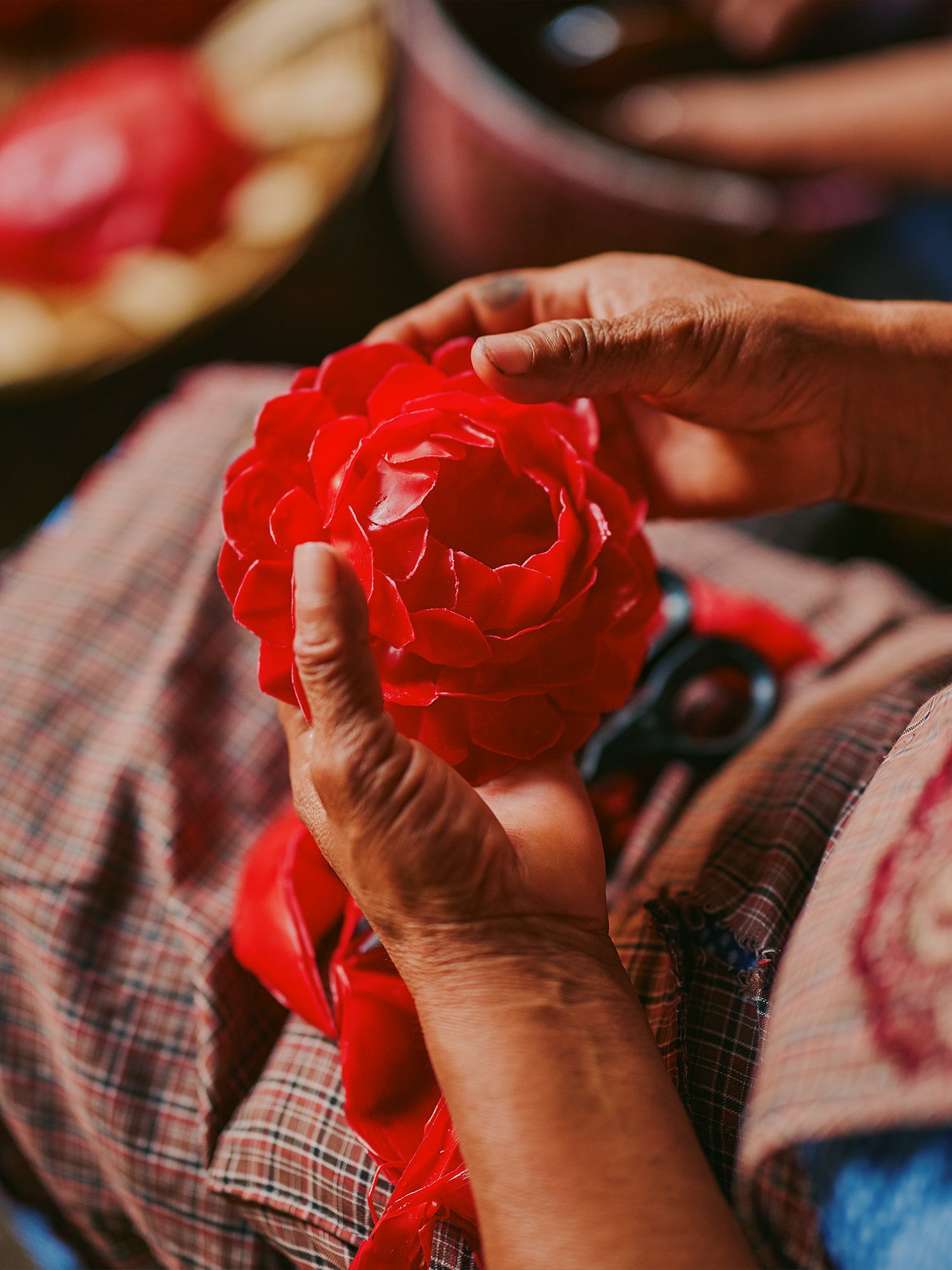 Hands shaping red wax rose candle in TeotitlÃ¡n del Valle, Mexico.