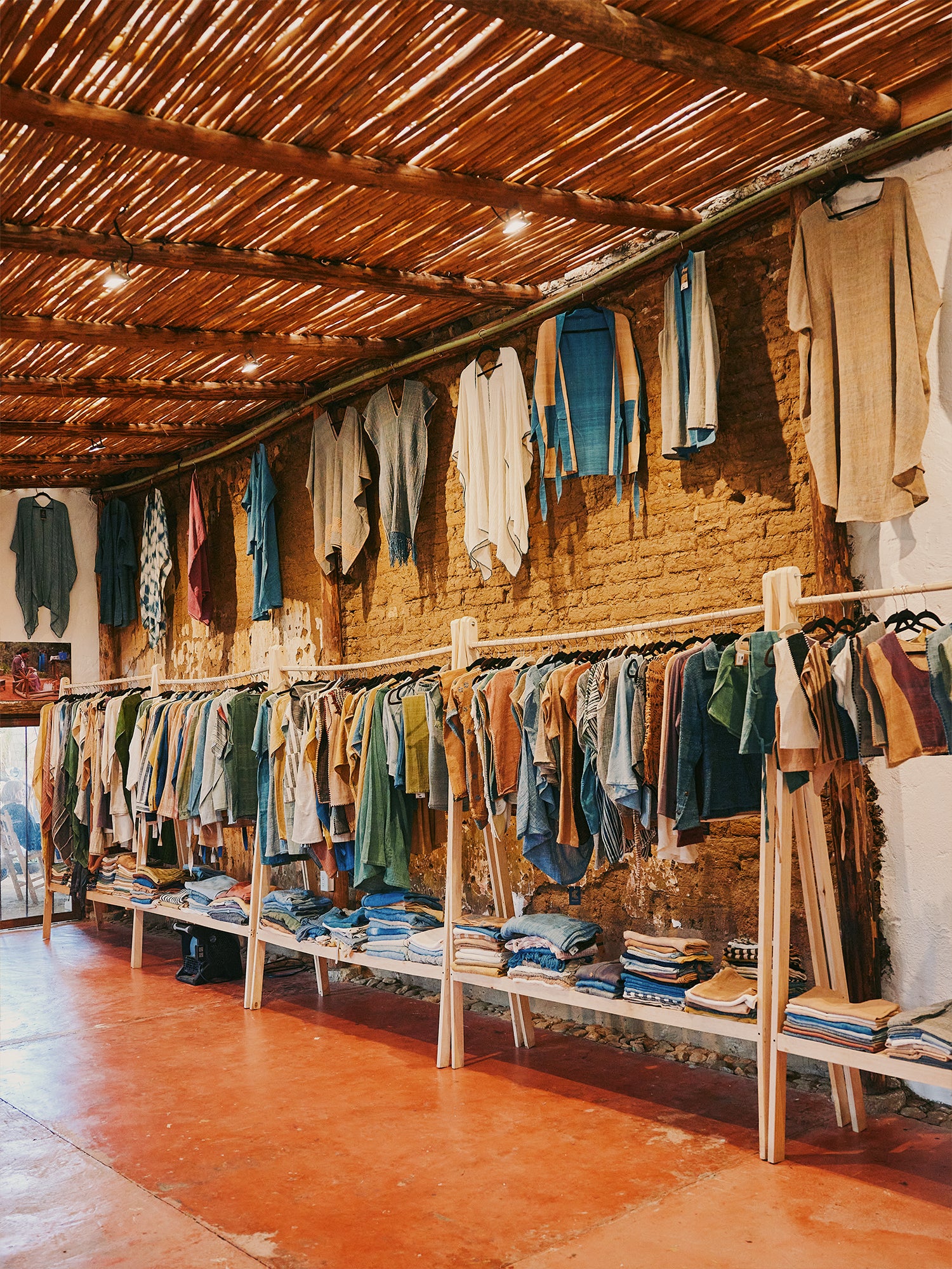 Long row of clothing rack with thatched ceiling in Oaxaca, Mexico.