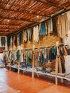 Long row of clothing rack with thatched ceiling in Oaxaca, Mexico.