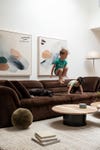 kids jumping on brown sofa