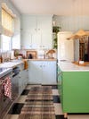 Green kitchen island wit plaid rug