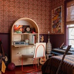 Teen bedroom with arched desk and 60s-inspired wallpaper.