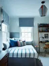 All-light blue teen bedroom with striped bedspread.
